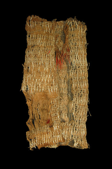 An ancient textile fragment featuring intricate woven patterns and red highlights against a dark background.