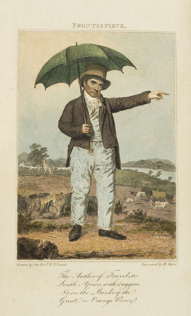 A man in Victorian attire holds a green umbrella, pointing while standing outdoors near a river and grazing cattle.